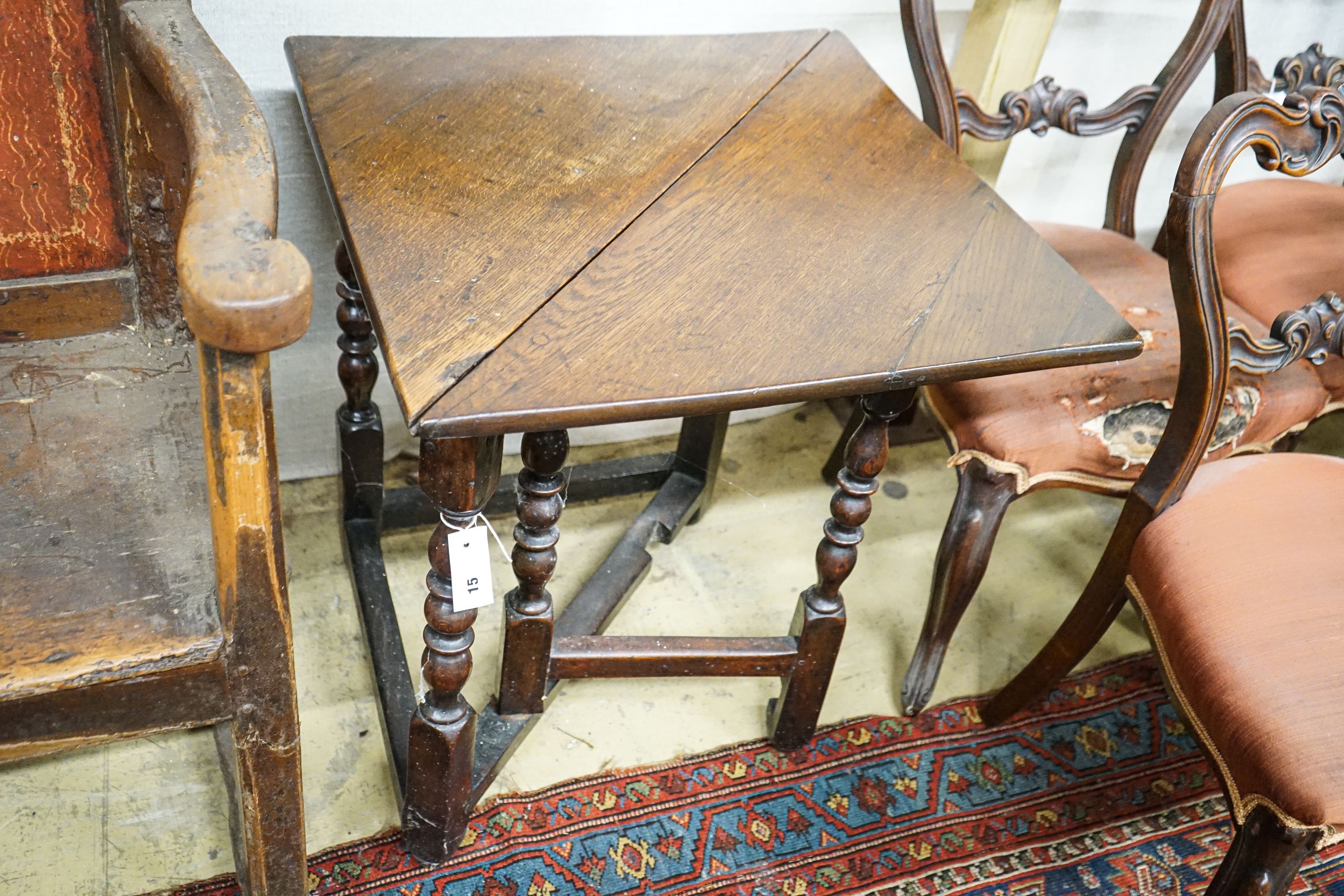 An early 18th century oak drop leaf table, with triangular flap and turned gateleg action underframe, width 62cm, depth 62cm, height 68cm